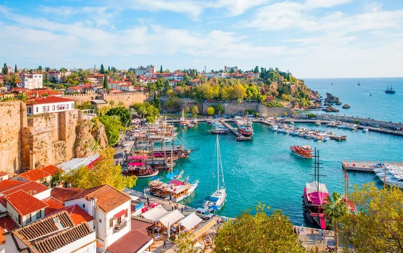 Boats in a harbour below a Turkish old town